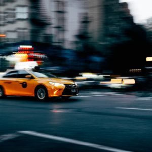 orange coupe running on gray street during daytiem